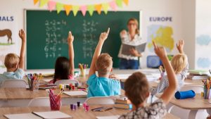 Aula moderna con estudiantes participando durante una clase en un colegio privado.